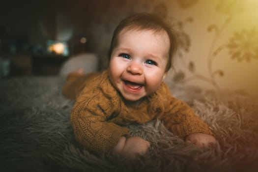 Smiling cute baby girl lying on bed fluffy cover. Adorable kid portrait. 5 month old child. Childhood concept. High quality photo