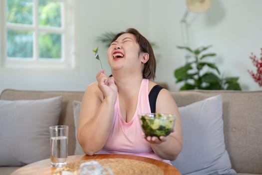 A joyful moment of an overweight woman embracing healthy food choices at home embarking on her weight loss journey.