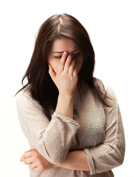 Woman with brown hair is looking down and holding her hand to her face, looking sad and thoughtful.