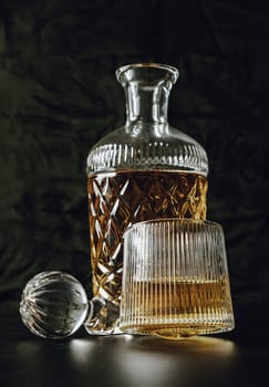 Design elements of The crystal decanter of whiskey, Glass Lid with Whiskey glass on dark background with reflection. use it as your Wallpaper, Poster and Copy space, Selective focus.