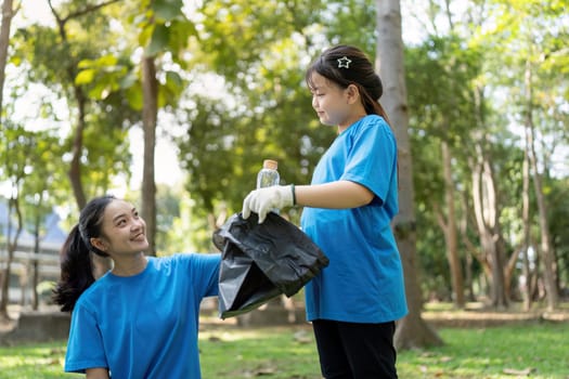 A mother and daughter duo engaging in a garbage collection activity, demonstrating teamwork and commitment to environmental cleanliness in a beautiful park setting.