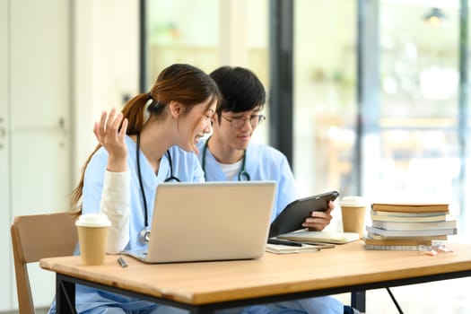 Medical students working together on assignments in a modern study space..