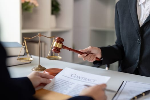 A lawyer showcasing a contract and holding a gavel, conveying authority and trust while engaging in a serious discussion with a client in a modern office.
