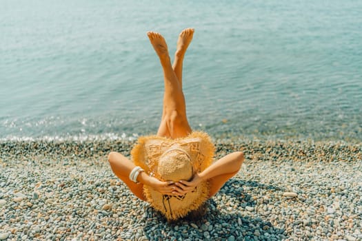 Beach Relaxation woman lies on a pebble beach, legs raised, and arms spread out. The concept of travel, vacation at sea.