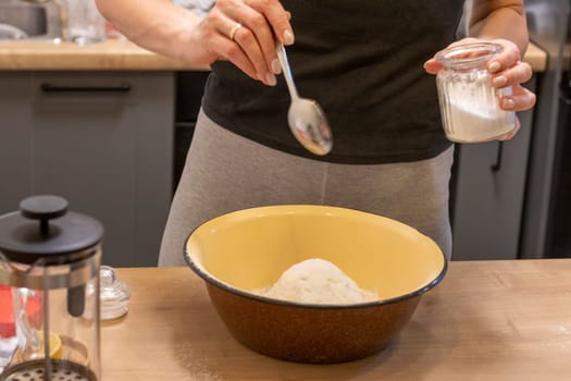 Woman adding ingredients together to prepare dough