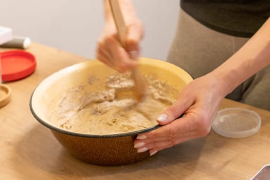 Woman kneads the dough in the bowl