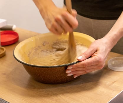 Woman kneads the dough in the bowl