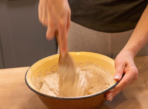Woman kneads the dough in the bowl