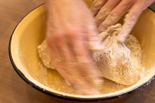 Woman kneads the dough in the bowl