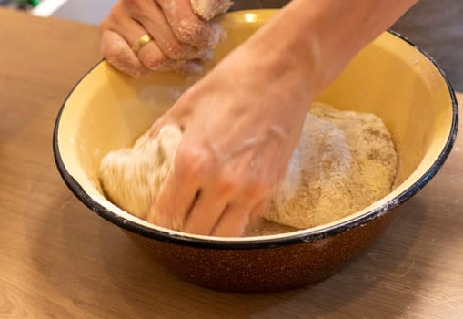 Woman kneads the dough in the bowl