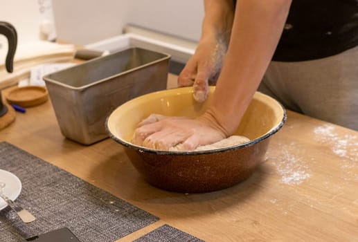 Woman kneads the dough in the bowl
