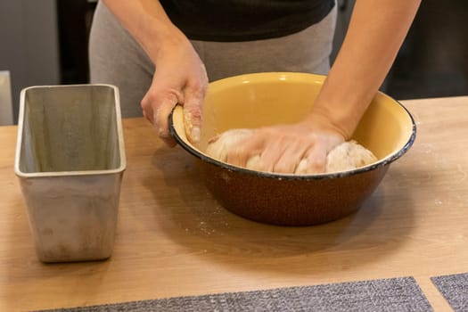 Woman kneads the dough in the bowl