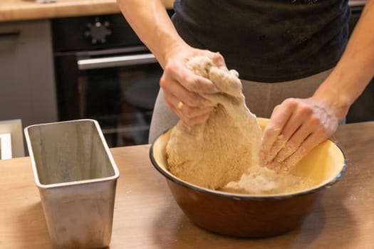 Woman kneads the dough in the bowl