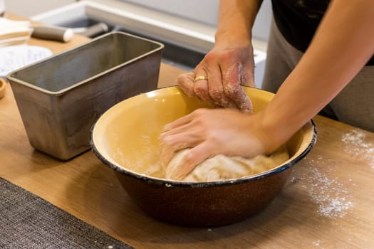 Woman kneads the dough in the bowl