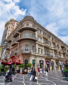 Baku, Azerbaijan - May 5, 2024: Visitors stroll along Nizami Street, admiring the architecture of historic buildings. Cafes and shops invite guests to explore the lively atmosphere and local culture