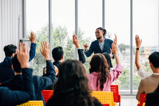A dynamic strategy session unfolds in the boardroom as business professionals engage with questions. Hands raised signify the active participation of colleagues and employees.