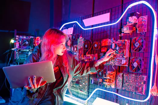 Cyber security. Software engineer holding laptop computer at data center checking hardware, Hacker woman service in server room, check circuit board with many small components
