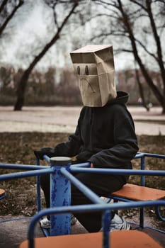 Photograph of a teen with a carton head mask . High quality photo