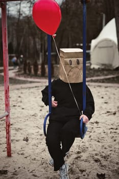 Photograph of a teen with a carton head mask . High quality photo