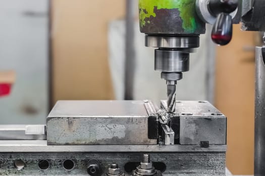 Old CNC milling machine for cutting stainless steel metal workpiece. Close-up of a cutter in action.