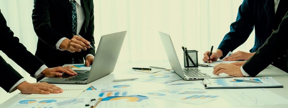 Business people in group meeting in formal attire share idea discussing report for company profit in creative workspace for start up business shot in close up view on group meeting table . Oratory .