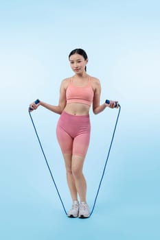 Young energetic asian woman in sportswear with jumping or skipping robe posing portrait in studio shot on isolated background. Cardio exercise tool and healthy body care lifestyle. Vigorous