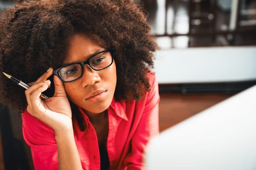 Portrait of young African woman creating website developer, thinking data information designer at home office, focusing on laptop. Concept of analytical data center in java project job. Tastemaker.