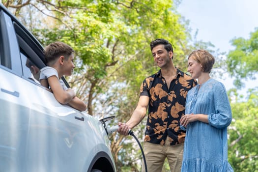 Family road trip vacation with electric vehicle, lovely family recharge EV car with green and clean energy. Natural and eco friendly car travel for sustainable environment. Perpetual