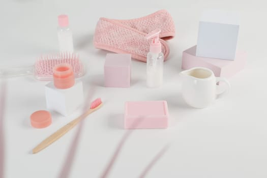 Skincare routine. Pink Women skincare products on white background. Soap, facial foam, cleansing, serum, cream lotion, toothbrush, lipstick. Beauty concept. Natural cosmetic pink flat lay top view.