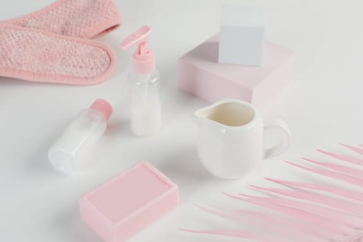 Skincare routine. Pink Women skincare products on white background. Soap, facial foam, cleansing, serum, cream lotion, toothbrush, lipstick. Beauty concept. Natural cosmetic pink flat lay top view.