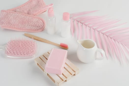 Skincare routine. Pink Women skincare products on white background. Soap, facial foam, cleansing, serum, cream lotion, toothbrush, lipstick. Beauty concept. Natural cosmetic pink flat lay top view.