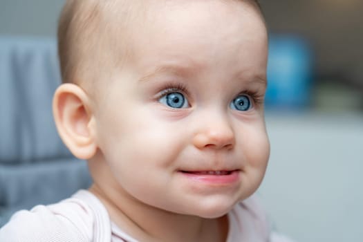 Smiling baby with bright blue eyes and a playful expression
