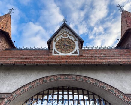 The intricate design of a historic building is showcased under a blue sky. Decorative elements atop the structure accentuate its cultural significance and unique charm.