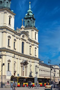 A vibrant photograph of St. Anne Church in Warsaw, Poland, showcasing its elegant Baroque architecture under a clear blue sky. The bright facade and intricate details make this historic landmark a perfect subject for cultural and architectural themes.