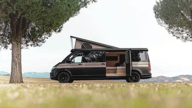 Modern camper van is parked on a grassy field with its side door open, revealing a cozy interior with wooden furniture. The van is surrounded by a peaceful countryside setting