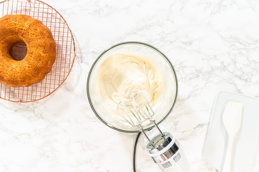 In a large mixing bowl, the ingredients are expertly mixed to create a delectable cream cheese buttercream for the Carrot Bundt Cake.