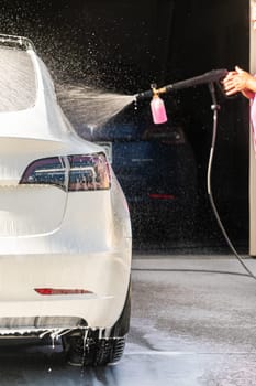 Efficiently cleaning an electric car in the comfort of a suburban driveway, combining eco-consciousness with practicality.