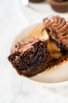 A delectable chocolate cupcake, sliced in half, elegantly presented on a plate.