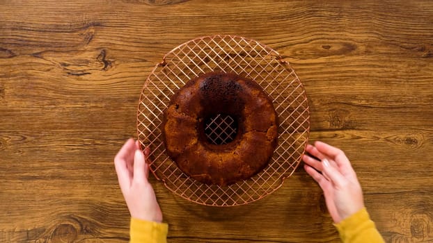 Flat lay. The gingerbread bundt cake gently eases out of its mold onto a wire rack, poised for a drizzle of sweet caramel frosting.