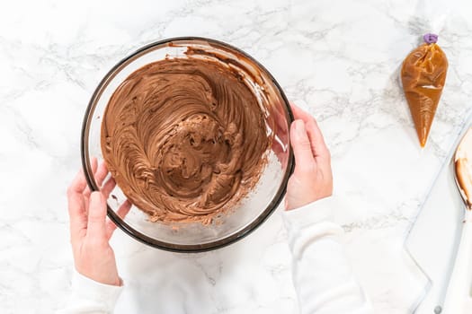 Flat lay. The frosting is whipped to perfection before being piped onto the delicious chocolate cupcakes.