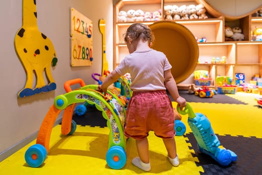 Child engaging with interactive toys and educational games in a bright play area