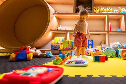 Toddler surrounded by colorful toys in an engaging indoor playroom designed for fun, learning, and creative exploration