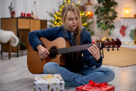 A cheerful girl is happily playing her guitar with joy, surrounded by Christmas gifts and vibrant festive decorations