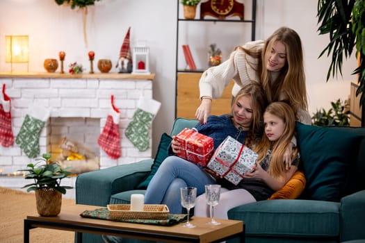 A heartwarming family scene joyfully celebrating the holidays and opening gifts together by the cozy fireplace