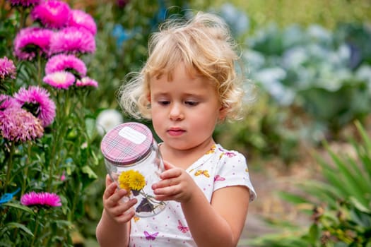 Happy girl catching a butterfly in the garden
