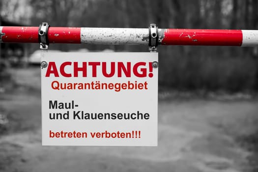 Sign with the German inscription Maul und Klauenseuche, betreten verboten. Translation: Foot and mouth disease, no trespassing