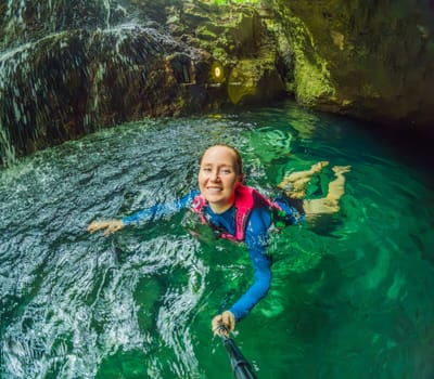 09.12.24, Playa Del Carmen, Mexico: Woman tourist in the water of a cenote at Xcaret park wearing a marked life jacket. Mexican tourism in natural parks. Adventure, relaxation, and eco-tourism concept in Quintana Roo.