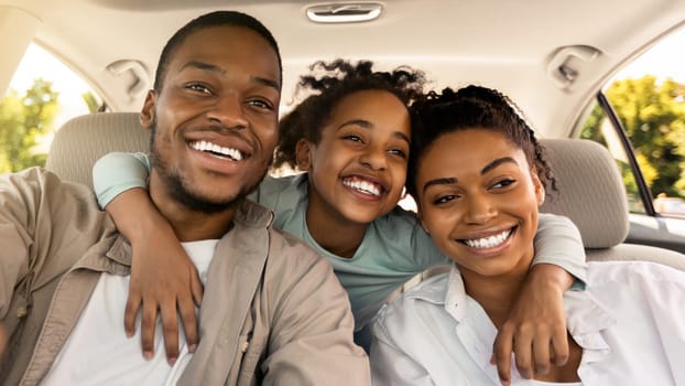 Cheerful Black Family Embracing Sitting In New Car Driving And Enjoying Road Trip On Summer Vacation. Parents And Daughter Posing In Auto. Automobile Rent And Purchase, Transportation Concept