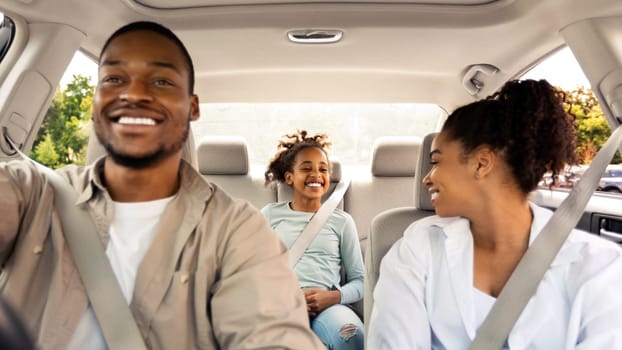 Joyful Black Family Driving New Car Having Ride In City. Parents And Daughter Sitting In Automobile Enjoying Road Trip On Vacation. Transportation Concept. Selective Focus