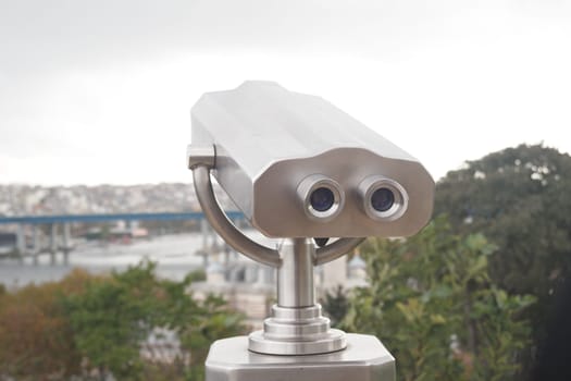 Coin-operated binoculars looking out over city buildings